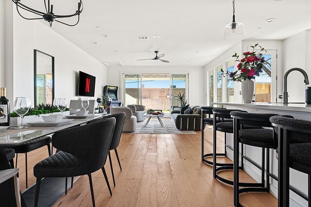 dining space with sink, ceiling fan, and light hardwood / wood-style flooring