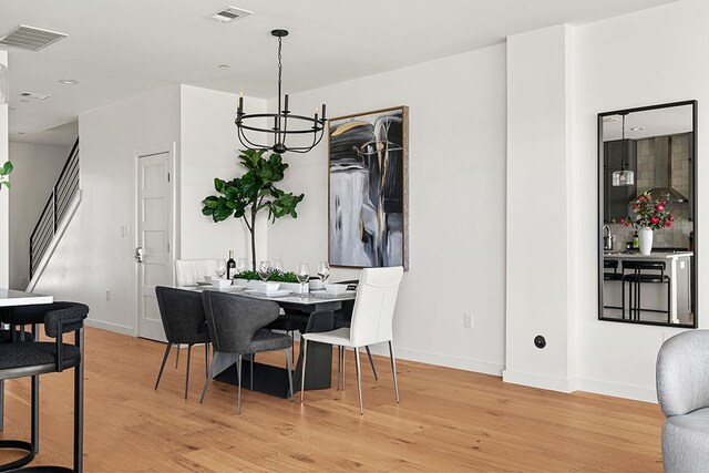 dining room with a chandelier and light wood-type flooring