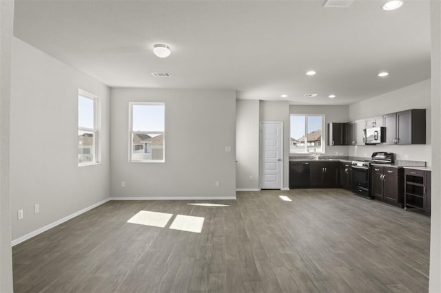 kitchen with appliances with stainless steel finishes and dark hardwood / wood-style floors