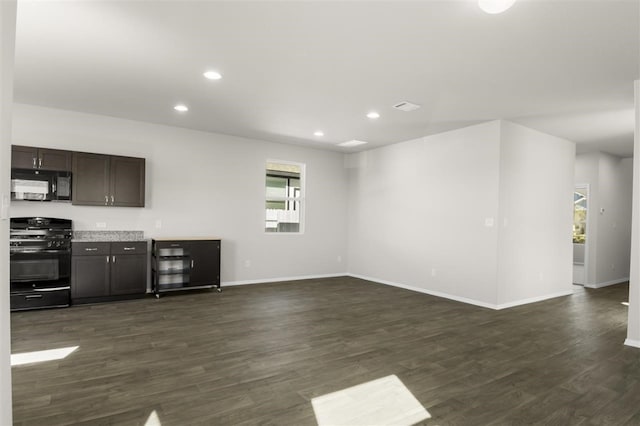 interior space featuring a wealth of natural light, dark wood-type flooring, and black appliances