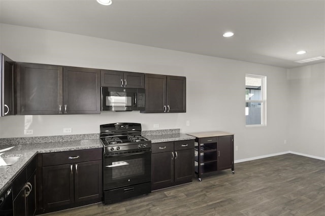 kitchen featuring black appliances, dark brown cabinetry, dark wood-type flooring, and light stone counters