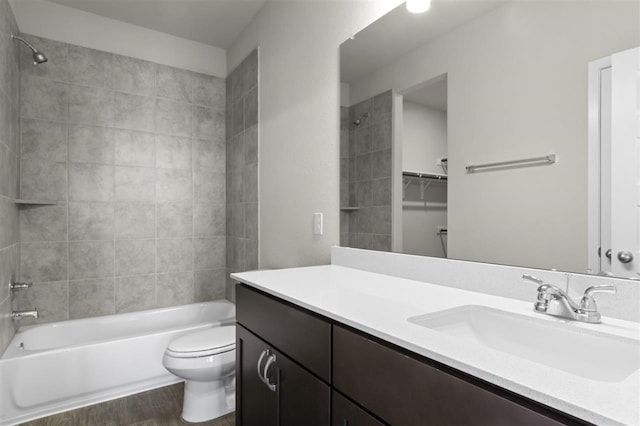 full bathroom featuring tiled shower / bath, vanity, toilet, and hardwood / wood-style flooring