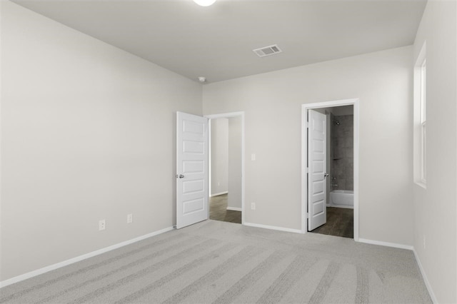 unfurnished bedroom featuring carpet floors and connected bathroom