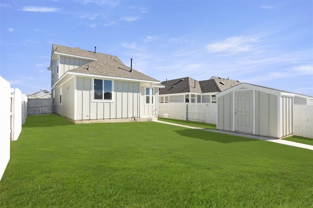 back of house with a lawn and a shed