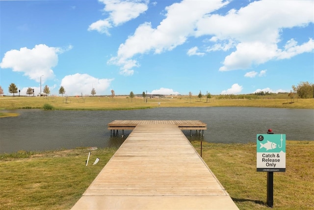 dock area with a rural view, a yard, and a water view