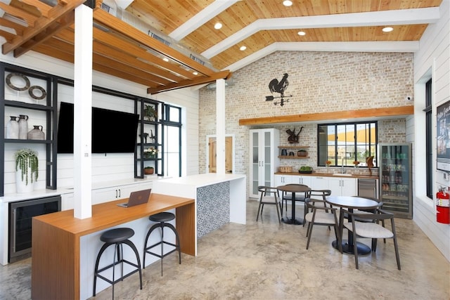 kitchen with wine cooler, high vaulted ceiling, and white cabinetry