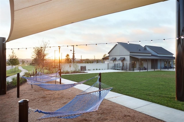 view of home's community with a lawn, a playground, and a patio