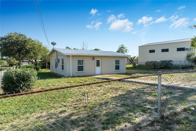 rear view of property featuring a lawn