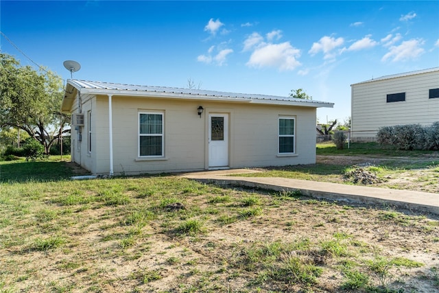 rear view of property featuring a yard