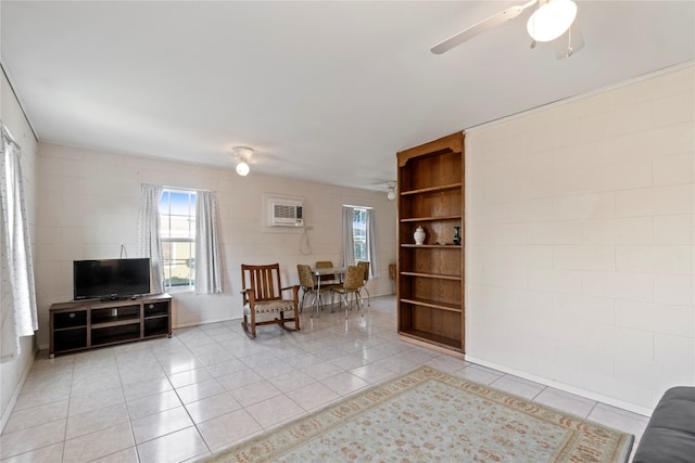 sitting room with ceiling fan, a wall mounted AC, and light tile floors