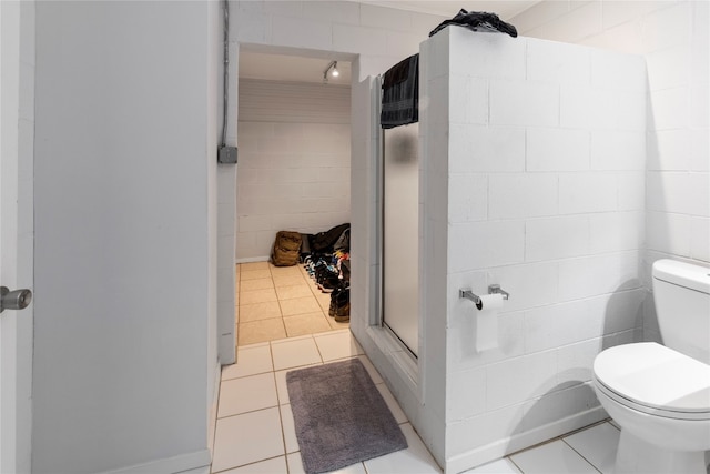 bathroom with walk in shower, tile flooring, toilet, and tile walls