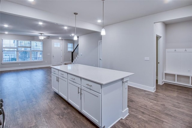 kitchen featuring decorative light fixtures, dark hardwood / wood-style floors, a kitchen island, ceiling fan, and white cabinets