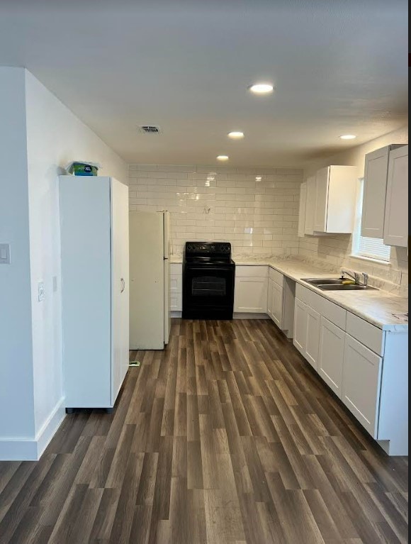 kitchen with white fridge, black electric range oven, sink, and backsplash