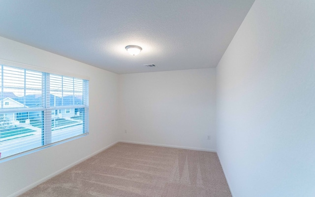 carpeted spare room with a textured ceiling