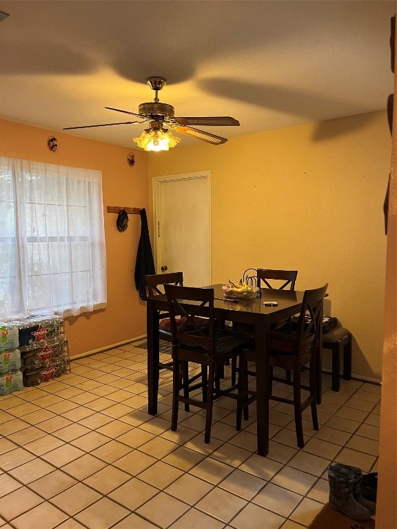 dining space featuring ceiling fan and light tile flooring