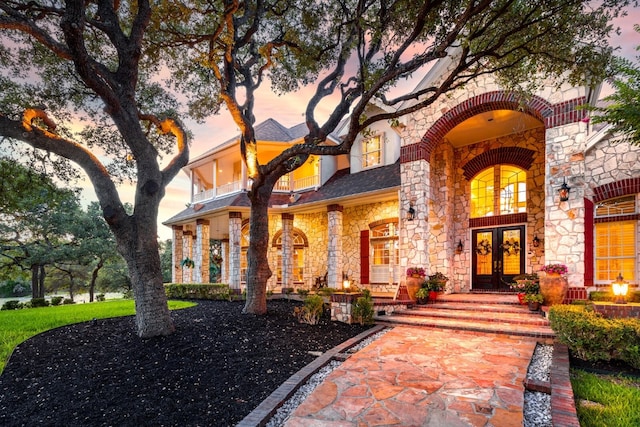 view of front facade with french doors and a balcony