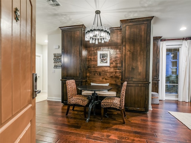 dining space with dark hardwood / wood-style floors and a chandelier