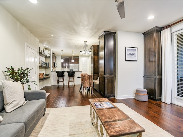 living room featuring an inviting chandelier and dark hardwood / wood-style floors