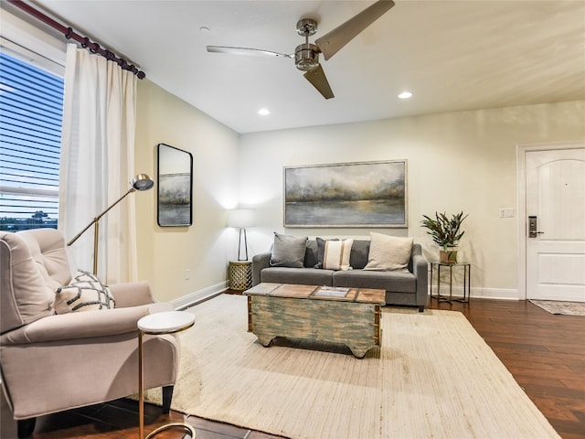 living room featuring ceiling fan and dark hardwood / wood-style flooring