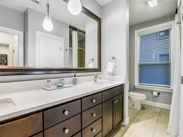 bathroom featuring toilet, tile floors, and vanity