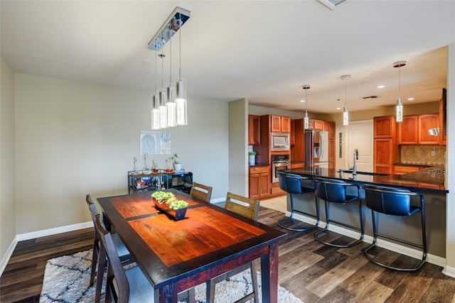 dining area featuring dark wood-type flooring and sink