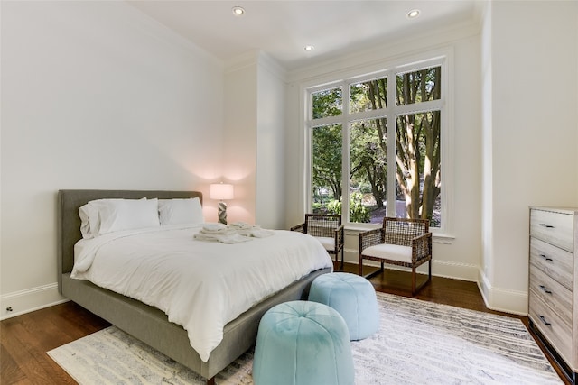 bedroom with dark hardwood / wood-style floors and crown molding