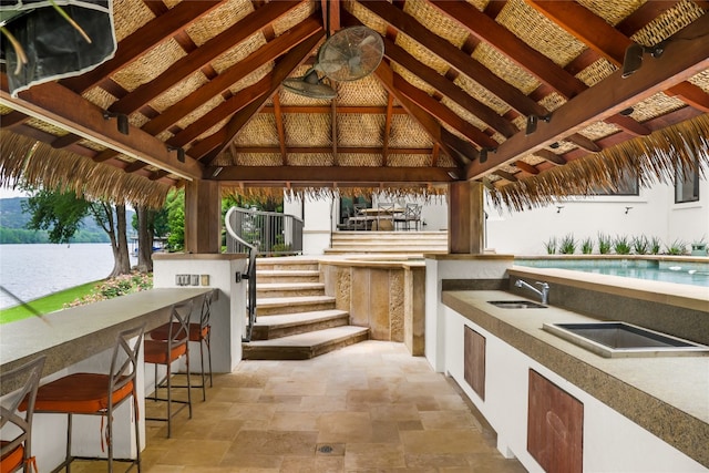 view of terrace featuring an outdoor kitchen, a gazebo, and an outdoor wet bar