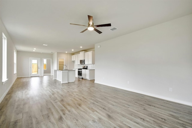 unfurnished living room featuring light hardwood / wood-style floors and ceiling fan