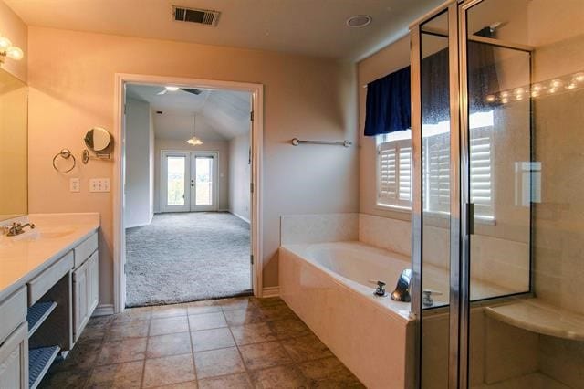 bathroom featuring french doors, separate shower and tub, large vanity, tile floors, and vaulted ceiling