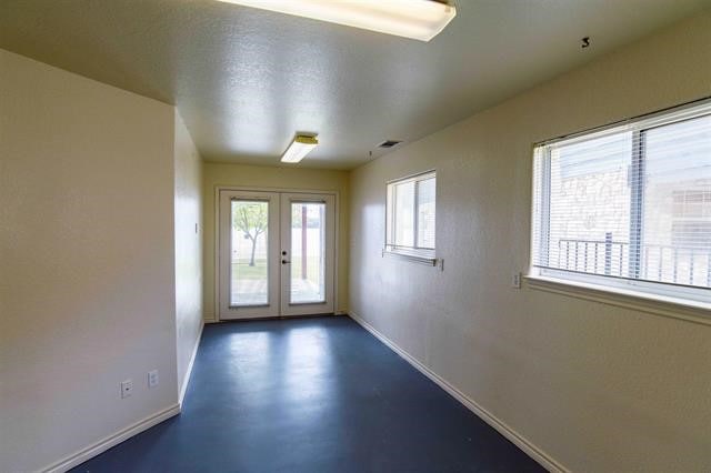 spare room featuring french doors and a textured ceiling