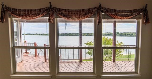 doorway to outside featuring a water view and a healthy amount of sunlight