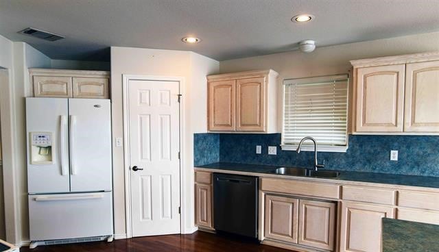 kitchen with black dishwasher, white fridge with ice dispenser, backsplash, and sink