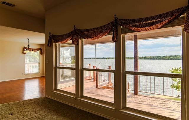 entryway featuring a chandelier, dark wood-type flooring, and a water view