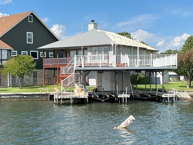 dock area with a deck with water view and a yard