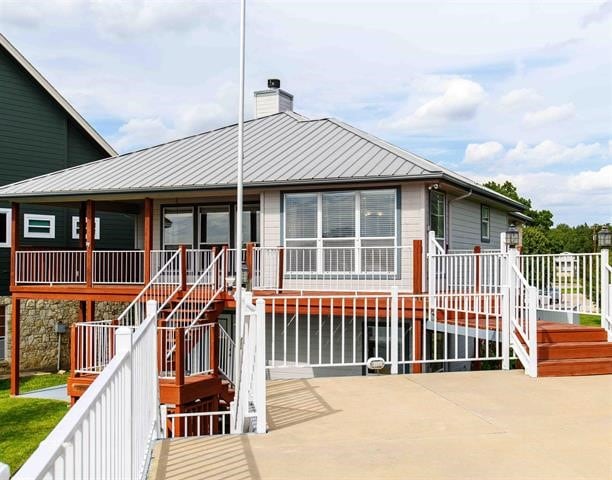 back of property featuring a patio and a wooden deck