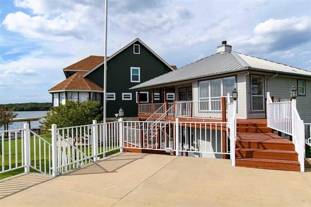 exterior space featuring a water view and a patio