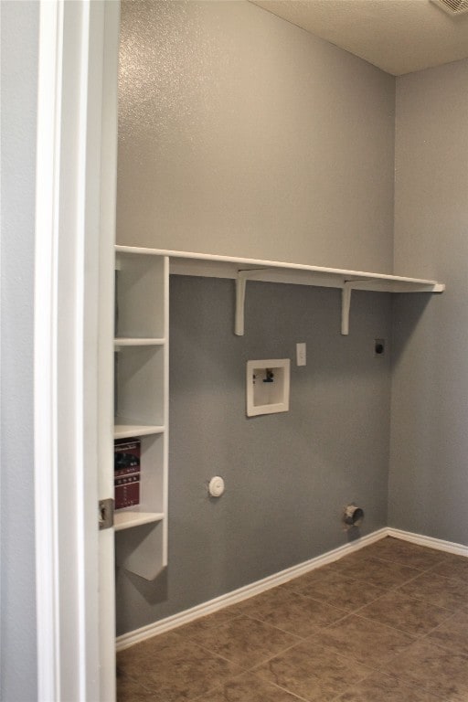 clothes washing area with hookup for a washing machine, hookup for a gas dryer, dark tile floors, and electric dryer hookup