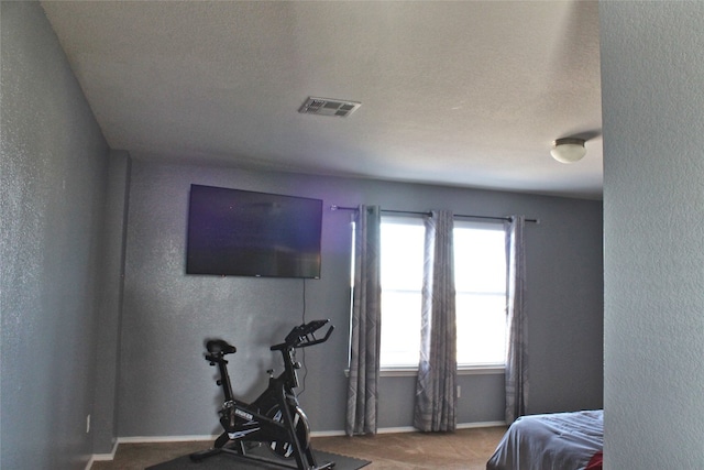 bedroom featuring a textured ceiling and dark colored carpet