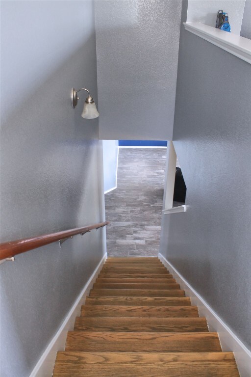 stairs with dark hardwood / wood-style floors