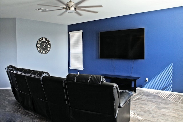 cinema with dark hardwood / wood-style floors and ceiling fan