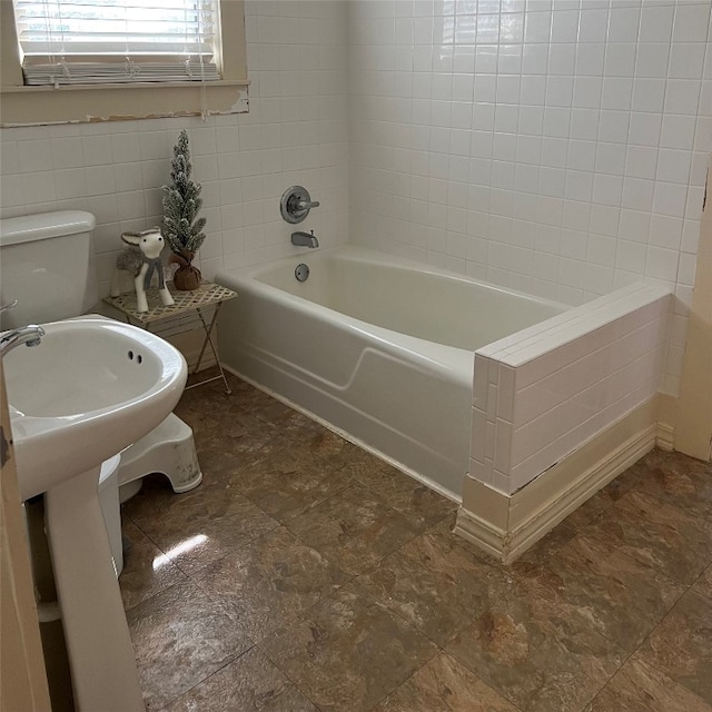 bathroom with tile floors, toilet, and tile walls