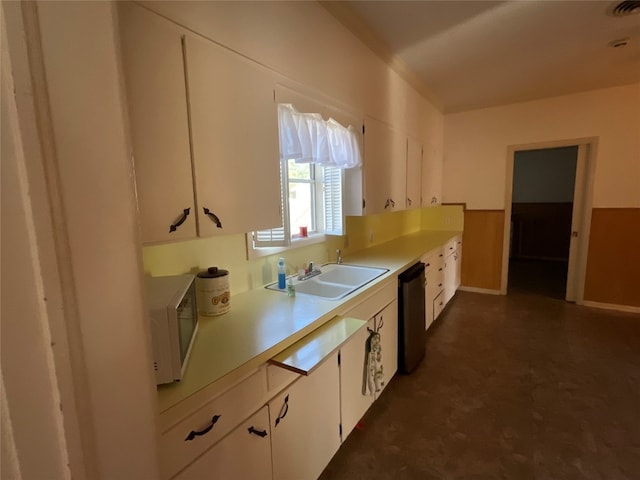 kitchen featuring black dishwasher, white cabinets, and sink