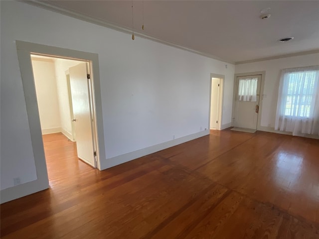 empty room with crown molding and light wood-type flooring