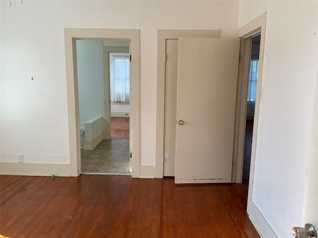 corridor with dark hardwood / wood-style flooring