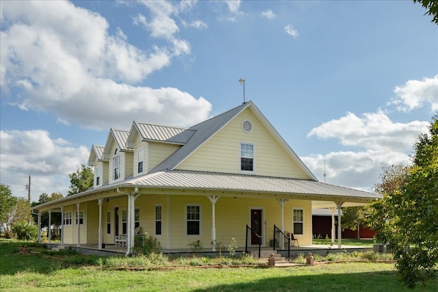 rear view of property featuring covered porch and a lawn