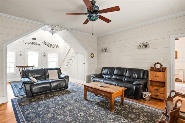 living room featuring hardwood / wood-style flooring, ornamental molding, and ceiling fan