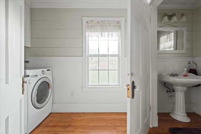 laundry room featuring hardwood / wood-style flooring, washer / clothes dryer, and crown molding