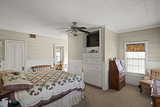 carpeted bedroom featuring ceiling fan and crown molding