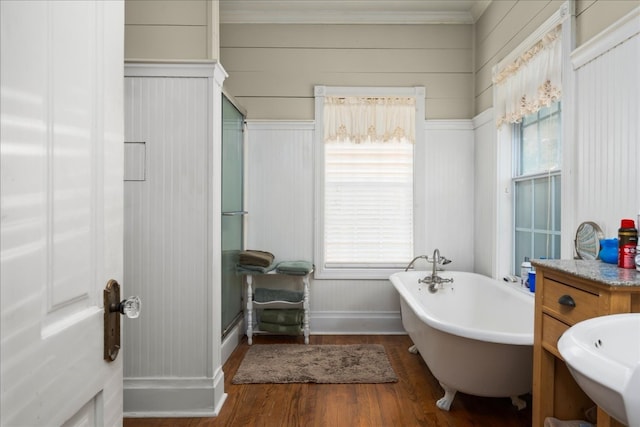 bathroom featuring plus walk in shower, ornamental molding, vanity, and hardwood / wood-style floors