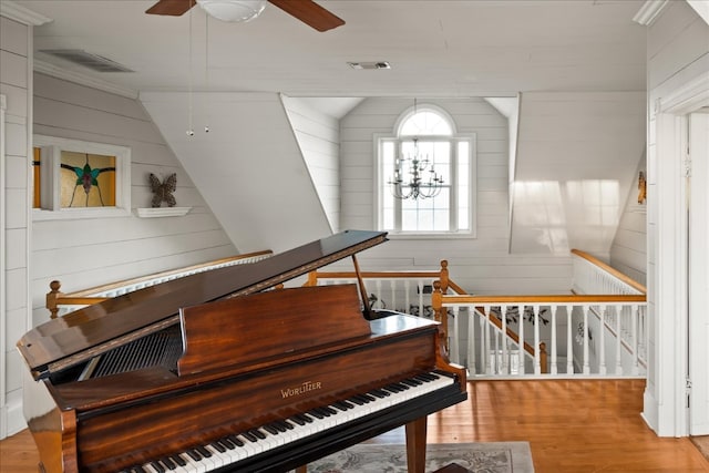 miscellaneous room with ceiling fan with notable chandelier, lofted ceiling, and light hardwood / wood-style floors